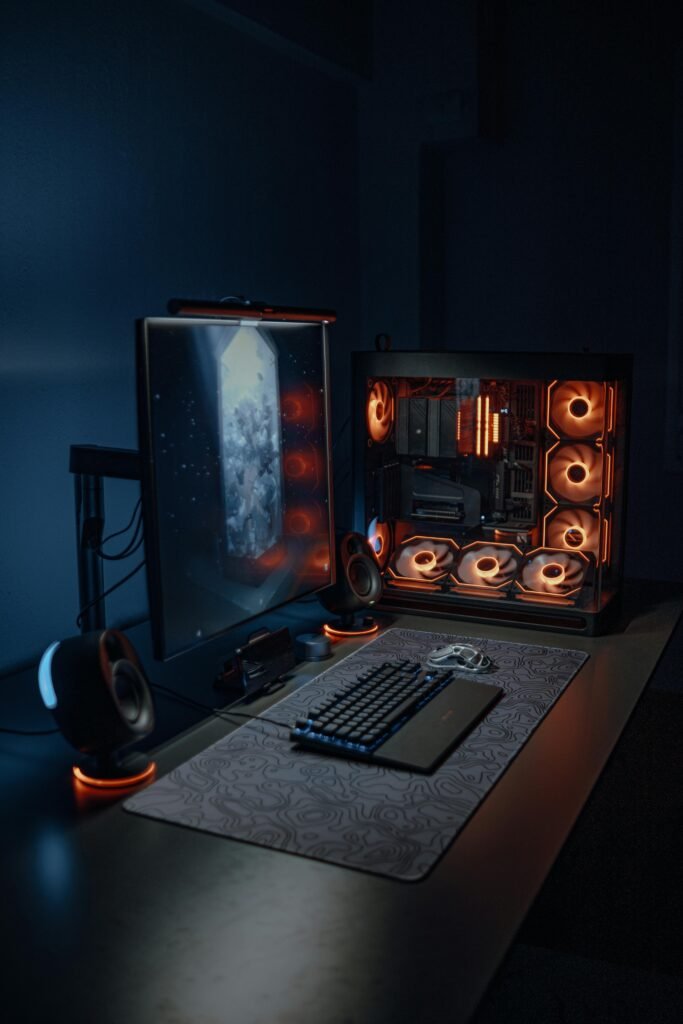 Sleek gaming workstation with RGB-lit PC and peripherals in a dimly lit room.